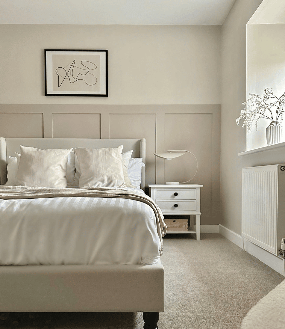 half wall bedroom wall panelling in neutral grey colour with yellow based white above it with a black framed print affixed to the wall