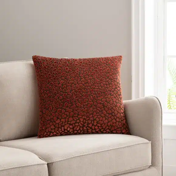 copper red cushion cover on a cream sofa